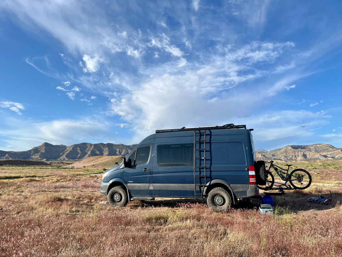 Dark blue RV rental van with mountain bike