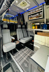Inside this modern RV rental, find versatile seating, an elevated bed, and clever storage, perfect for comfortable mobile living.