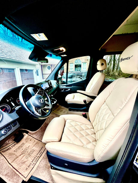 Experience the luxurious interior of this RV rental, featuring cream quilted leather seats and a modern Mercedes-Benz van cockpit.
