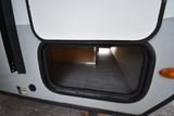 RV rental: Open exterior storage compartment reveals a spacious underbelly with patterned flooring.