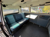 Spacious van interior for your next rv rental adventure. Features comfortable seating, a convenient table, and scenic views.