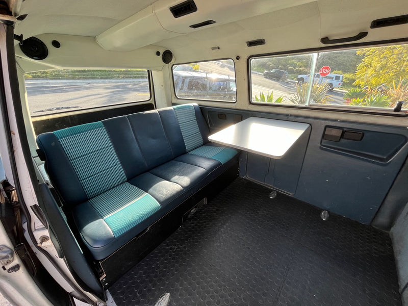 Spacious van interior for your next rv rental adventure. Features comfortable seating, a convenient table, and scenic views. — photo 7