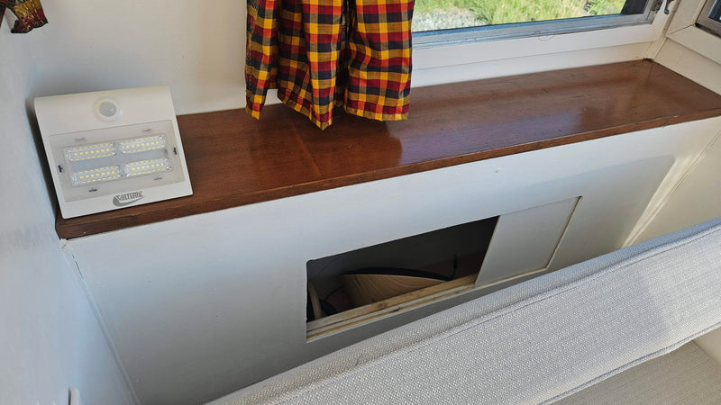 Smart storage solutions in an RV rental: a built-in bench with a hidden compartment, Valterra LED light, and window. — photo 11