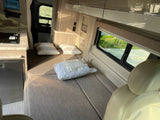 Relax in this rv rental's compact interior: a convertible bed, mini-kitchen, and tablet holder for your next adventure.
