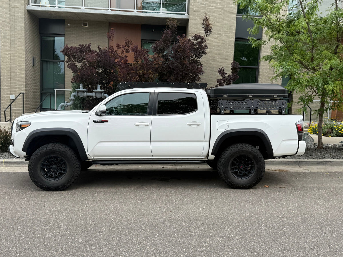 A white Toyota Tacoma TRD Pro pickup truck with a rooftop tent, an overlanding rig ready for adventure, like an RV rental. — photo 15