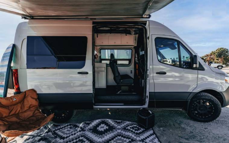  is set up for a relaxing outdoor adventure.|Inside a modern rv rental camper van: bright orange benches — photo 3