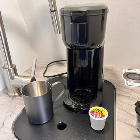 RV rental coffee convenience: A black single-serve maker, stainless mug, and Cafe Bustelo K-cup ready for use.