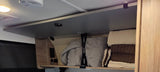 RV rental overhead cabinet reveals organized blankets, towels, and power outlets, offering convenient storage.