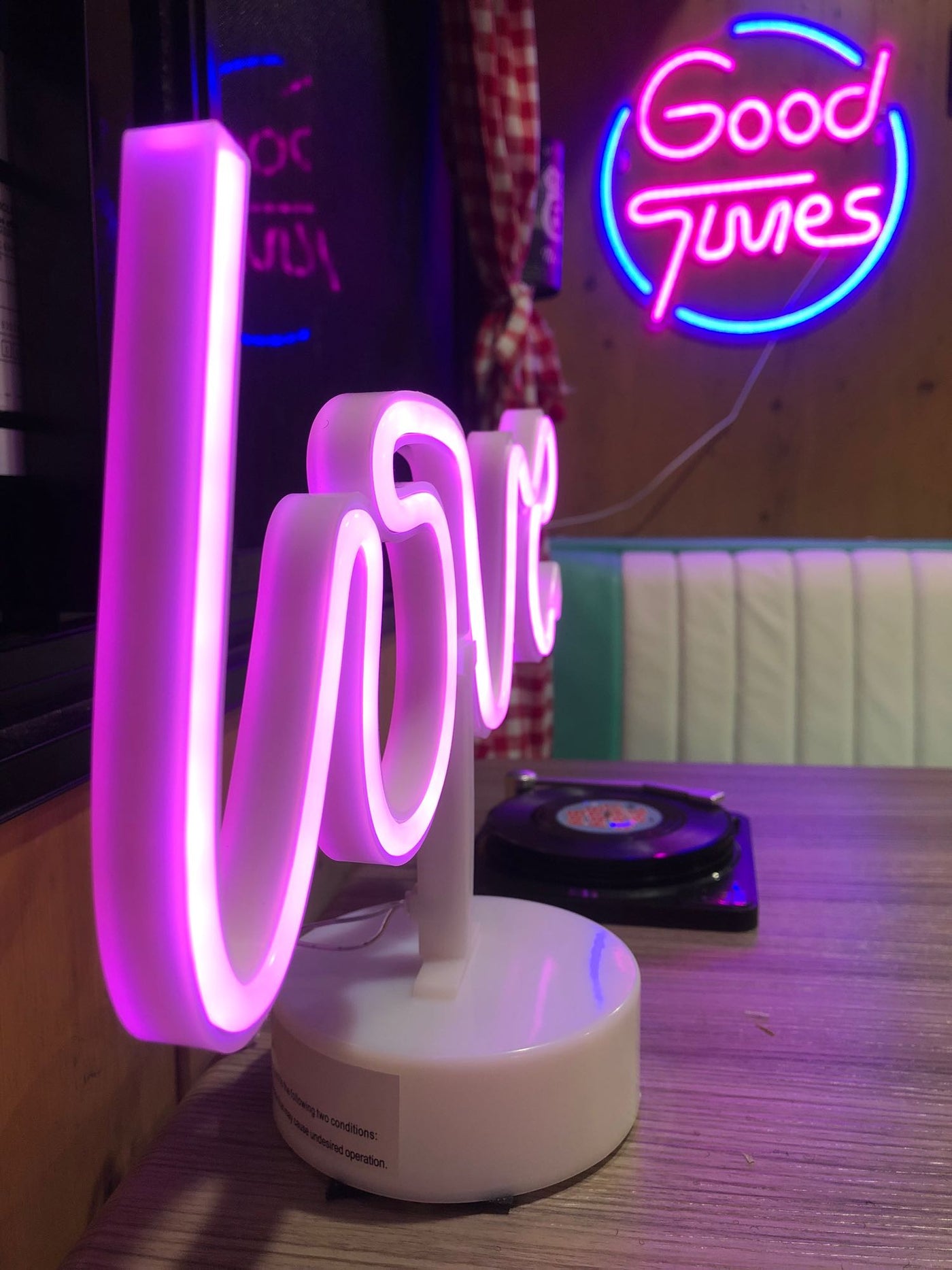 Inside a stylish rv rental, a glowing neon 'LOVE' sign, 'Good Times' sign, and record player create a fun atmosphere. — photo 6