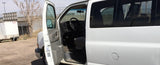 White Chevrolet Express-style van for RV rental has its driver's door open, showing the interior.