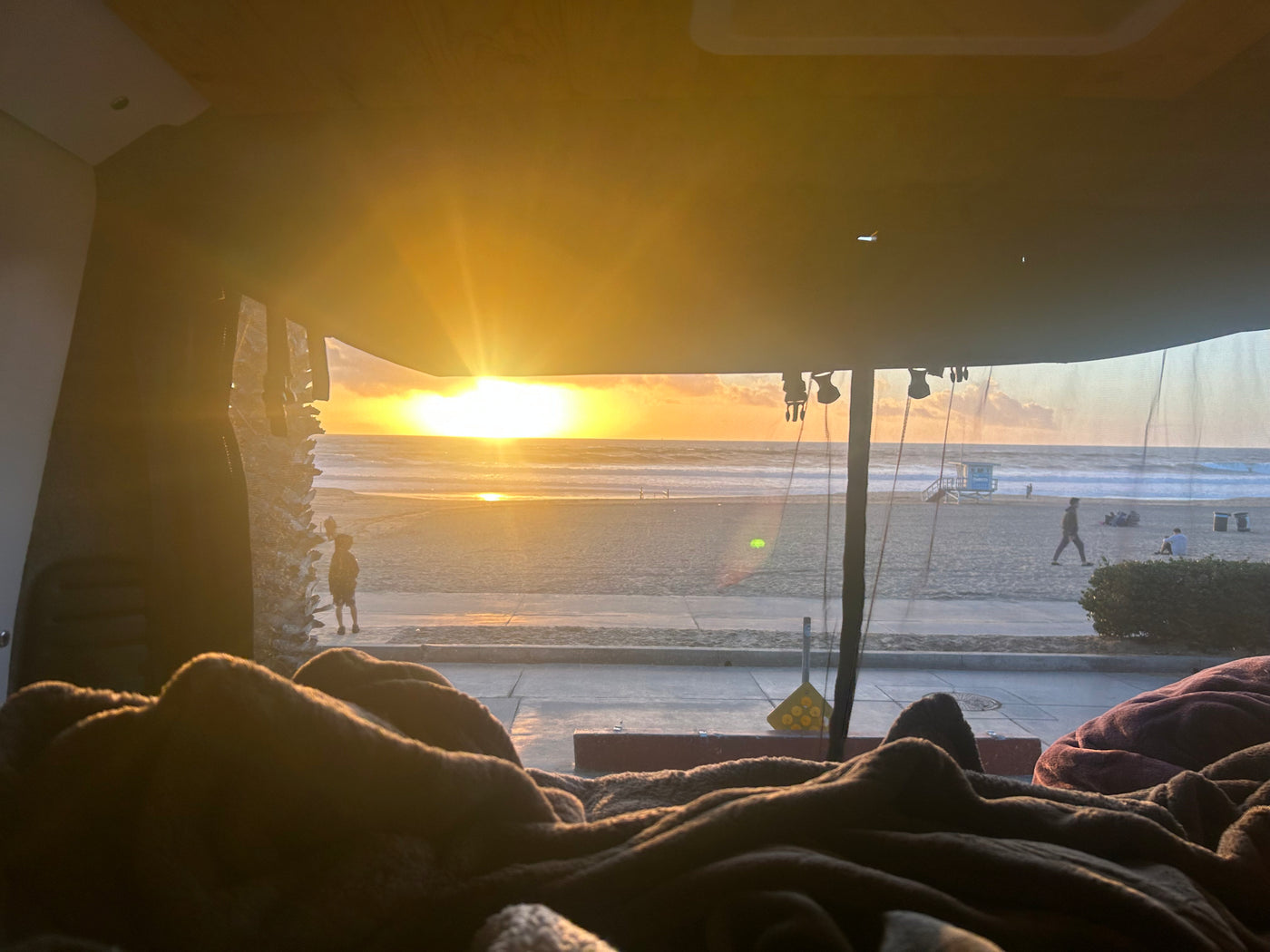 Enjoy a stunning beach sunset from this comfy RV rental. Watch people stroll the sandy shore near the ocean. — photo 6