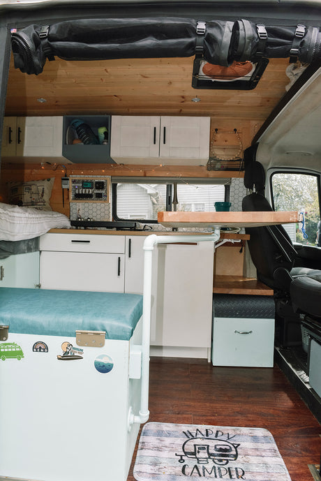 Cozy rv rental interior with compact kitchen, sleeping area, wood accents, and smart storage, perfect for mobile living.