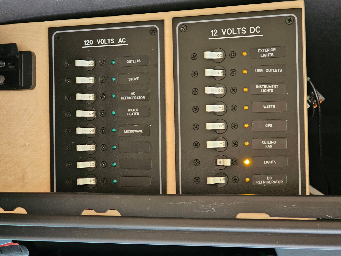 RV rental electrical panel with clearly labeled 120V AC & 12V DC switches for controlling onboard appliances & lights.