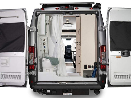 This RV rental's open rear shows a functional wet bath with toilet/shower and built-in cabinetry, ready for adventure.