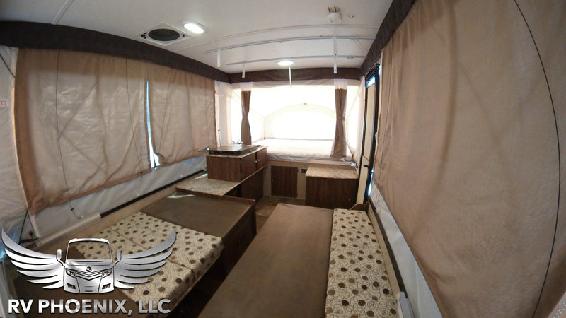 Spacious pop-up camper interior, ideal for RV rental. Features multiple beds, compact kitchen, and bright windows. — photo 9