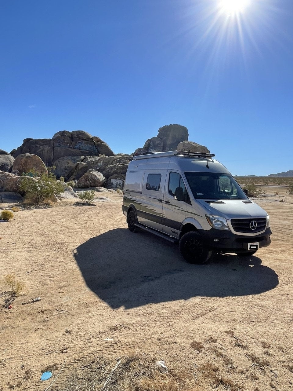 Silver RV rental van on a sunny desert landscape with large rocks. Perfect for your next off-grid adventure. — photo 5