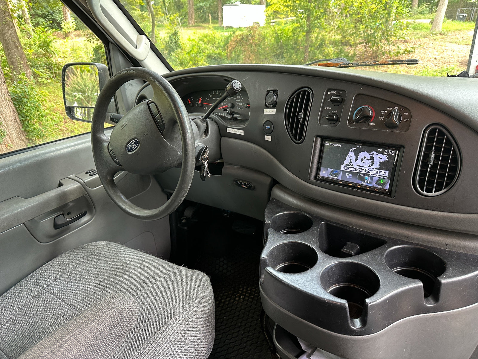 RV rental interior: Dashboard, steering wheel, radio, climate controls, & cupholders visible from the driver's seat.