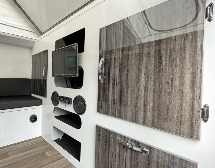  and a comfortable bed. Perfect for camping!|This grey and black rv rental pop-up camper is set up outdoors with an extended awning
