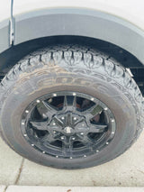 Close-up of a sturdy black all-terrain tire and glossy black rim on an RV rental, ready for travel adventures.