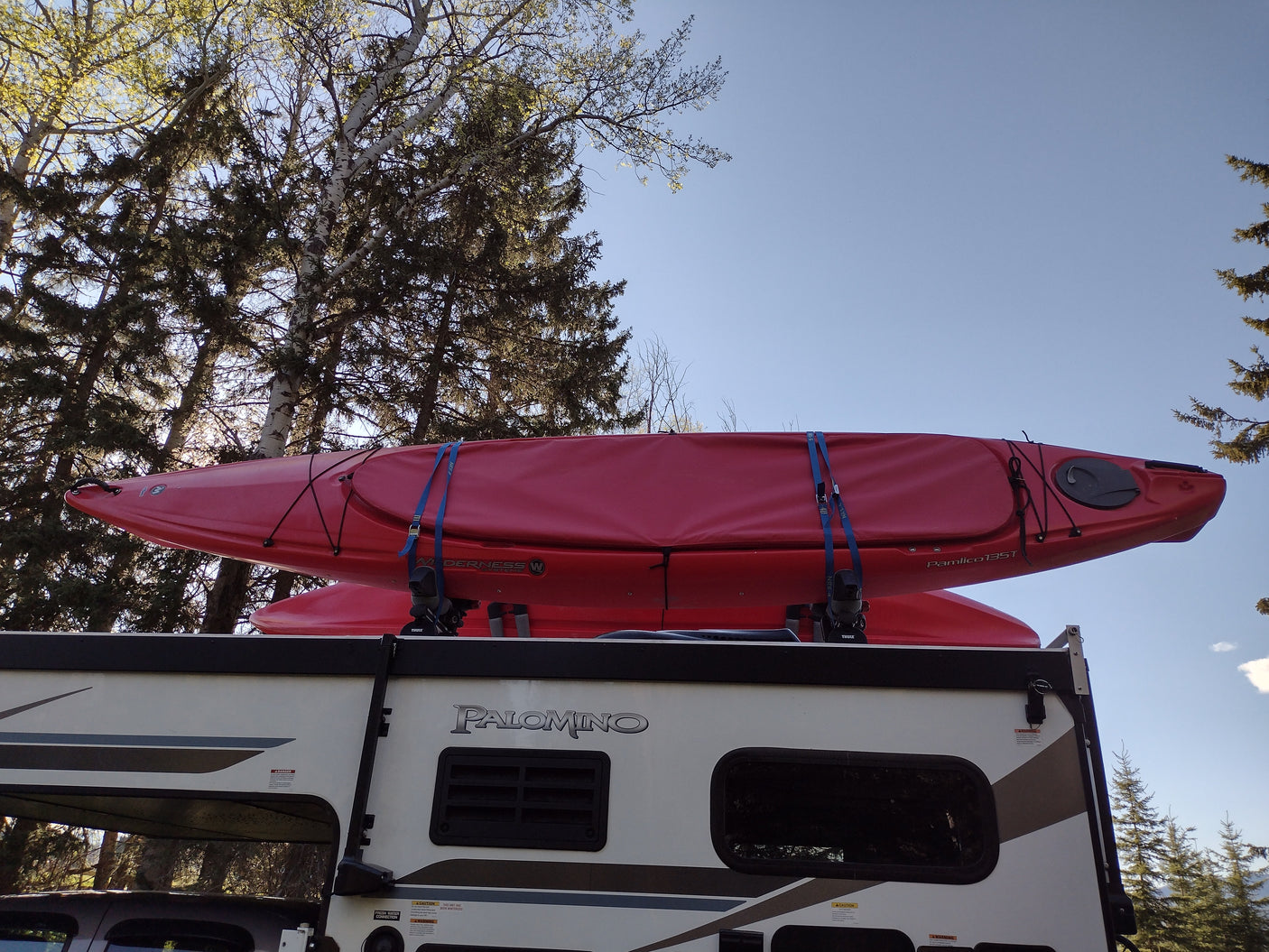 Red kayaks securely mounted on an RV roof, ready for adventure. Palomino RV rental is ideal for outdoor trips.