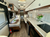 RV rental interior featuring a functional kitchen, twin beds, and ample storage for comfortable travel.