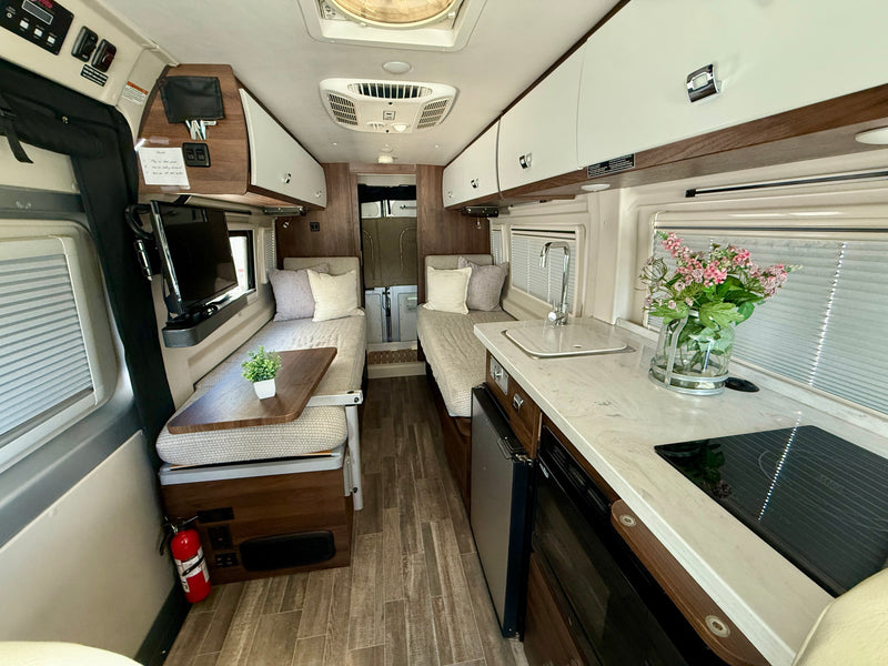 RV rental interior featuring a functional kitchen, twin beds, and ample storage for comfortable travel. — photo 13