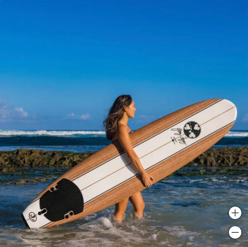A woman with long hair stands in the ocean, holding a wooden surfboard. This serene coastal adventure is perfect after an RV rental journey. — photo 16