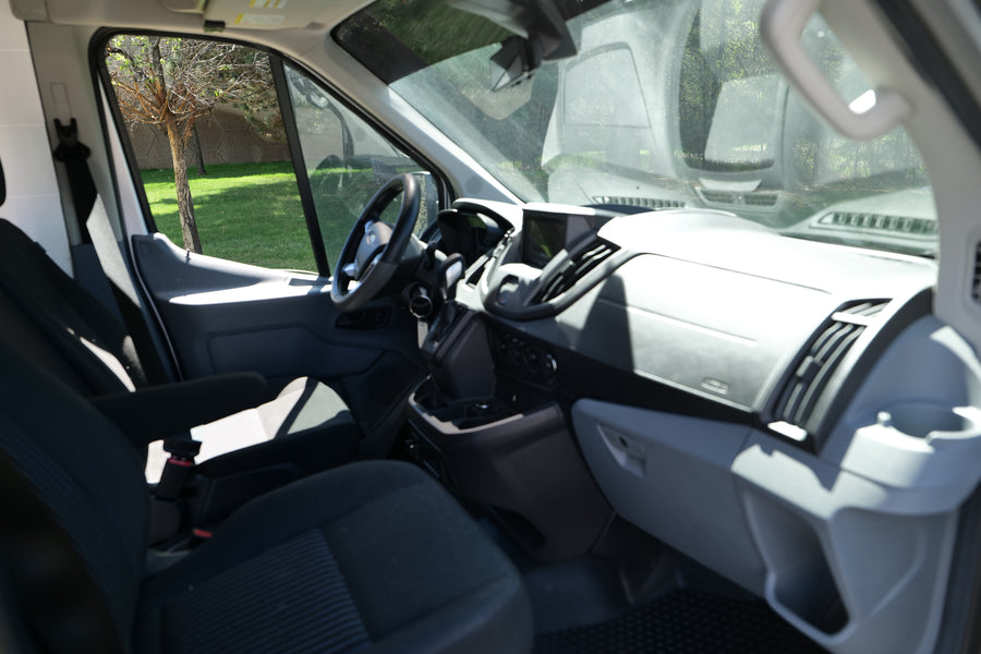 Spacious RV rental van interior, featuring the driver's cabin, dashboard, steering wheel, and front seats.