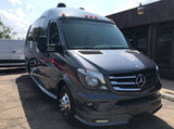 Sleek gray Mercedes Sprinter van, custom-fitted for rv rental, with red graphics, roof lights, and a custom front bumper.