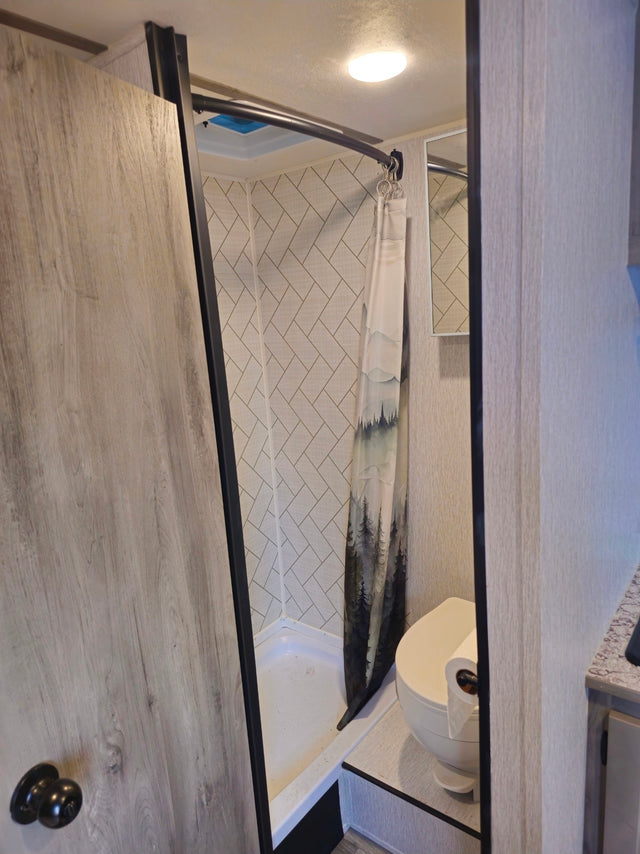  parked by a chain-link fence.|RV rental interior with compact kitchen