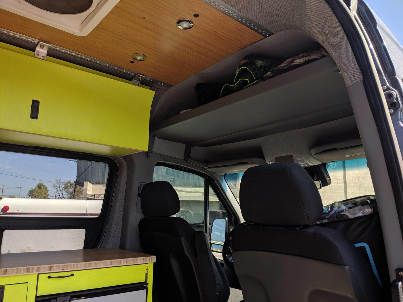 Step inside this RV rental's cozy interior, featuring vibrant lime green cabinets, a wood ceiling, and front cabin view. — photo 4