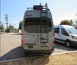 Back view of a grey Mercedes-Benz Winnebago Revel Sprinter RV with ladder and roof rack, ready for rv rental adventures.