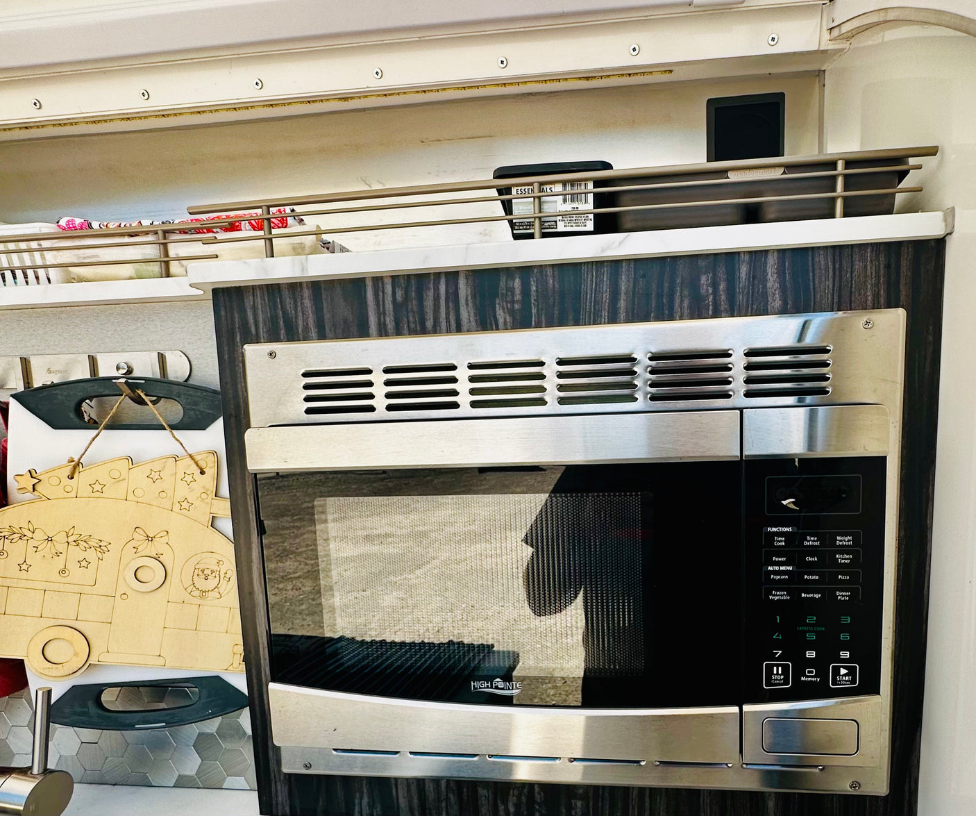 An RV rental kitchen featuring a built-in High Pointe microwave, madesmart storage organizers, and festive decor.