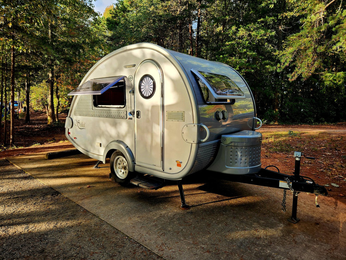  and front storage. Perfect for outdoor adventures.|This image features a stylish gray RV rental teardrop trailer parked at a scenic campsite under a vibrant sunset sky.|A sleek — photo 2
