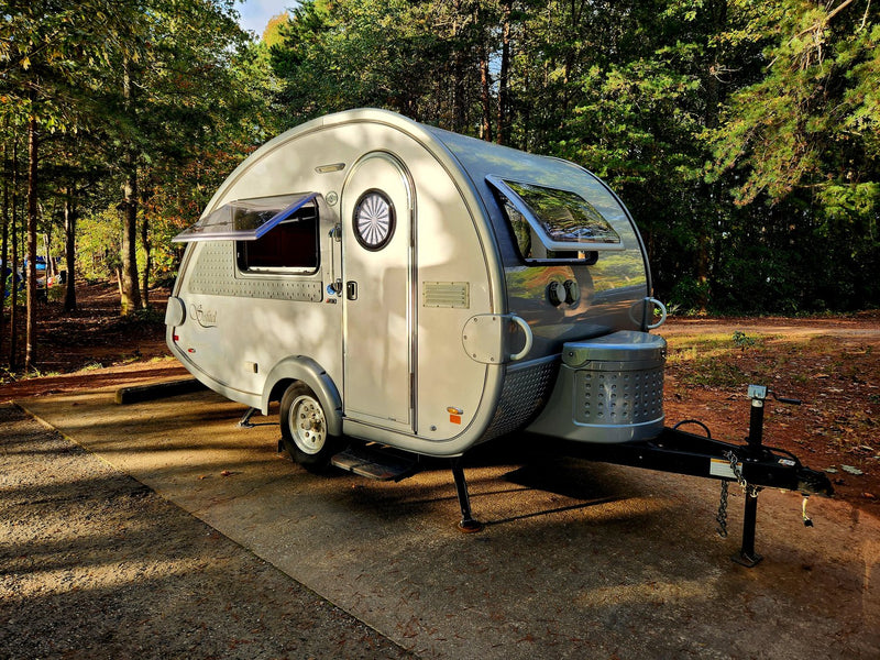 and front storage. Perfect for outdoor adventures.|This image features a stylish gray RV rental teardrop trailer parked at a scenic campsite under a vibrant sunset sky.|A sleek — photo 2