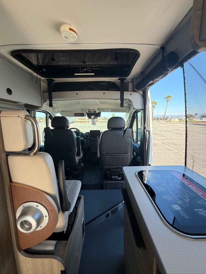 showing interior kitchen and seating.|RV rental: Inside a Winnebago Solis camper van. View shows cockpit — photo 5