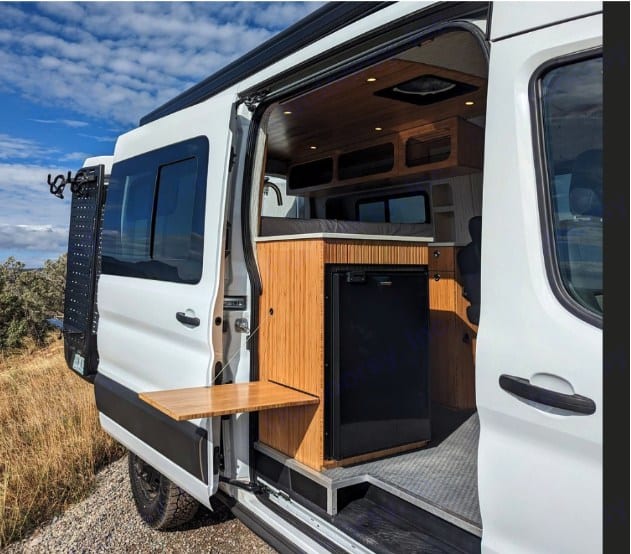  and scenic outdoor view from the back windows.|This RV rental's versatile camper van interior features flexible seating — photo 6