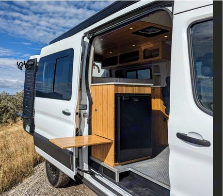 This modern rv rental showcases a cozy wood interior, pull-out table, and fridge for your adventures.