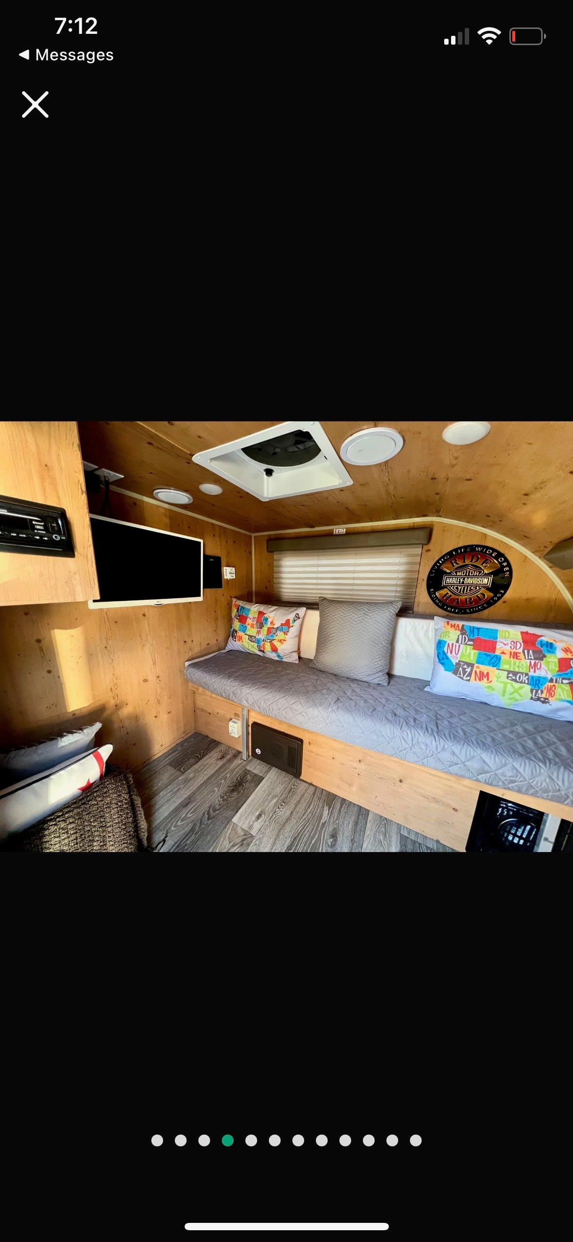 Cozy RV rental interior with wooden walls, small TV, comfy bed/bench, and storage, ready for your travel adventures. — photo 6