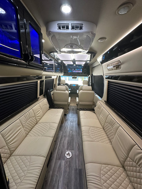 Experience a luxury rv rental! Spacious interior with plush cream seating, wood floors, and modern amenities.