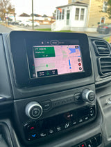 Inside an RV rental van: navigation display showing a map, next turn, and arrival details on the dashboard.