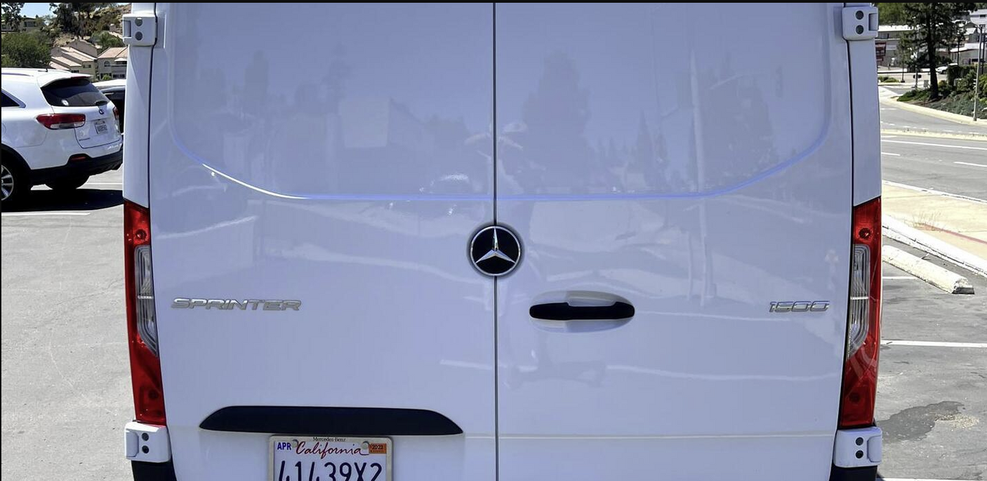 Rear view of a white Mercedes-Benz Sprinter 1500 van, popular for RV rental and conversions.