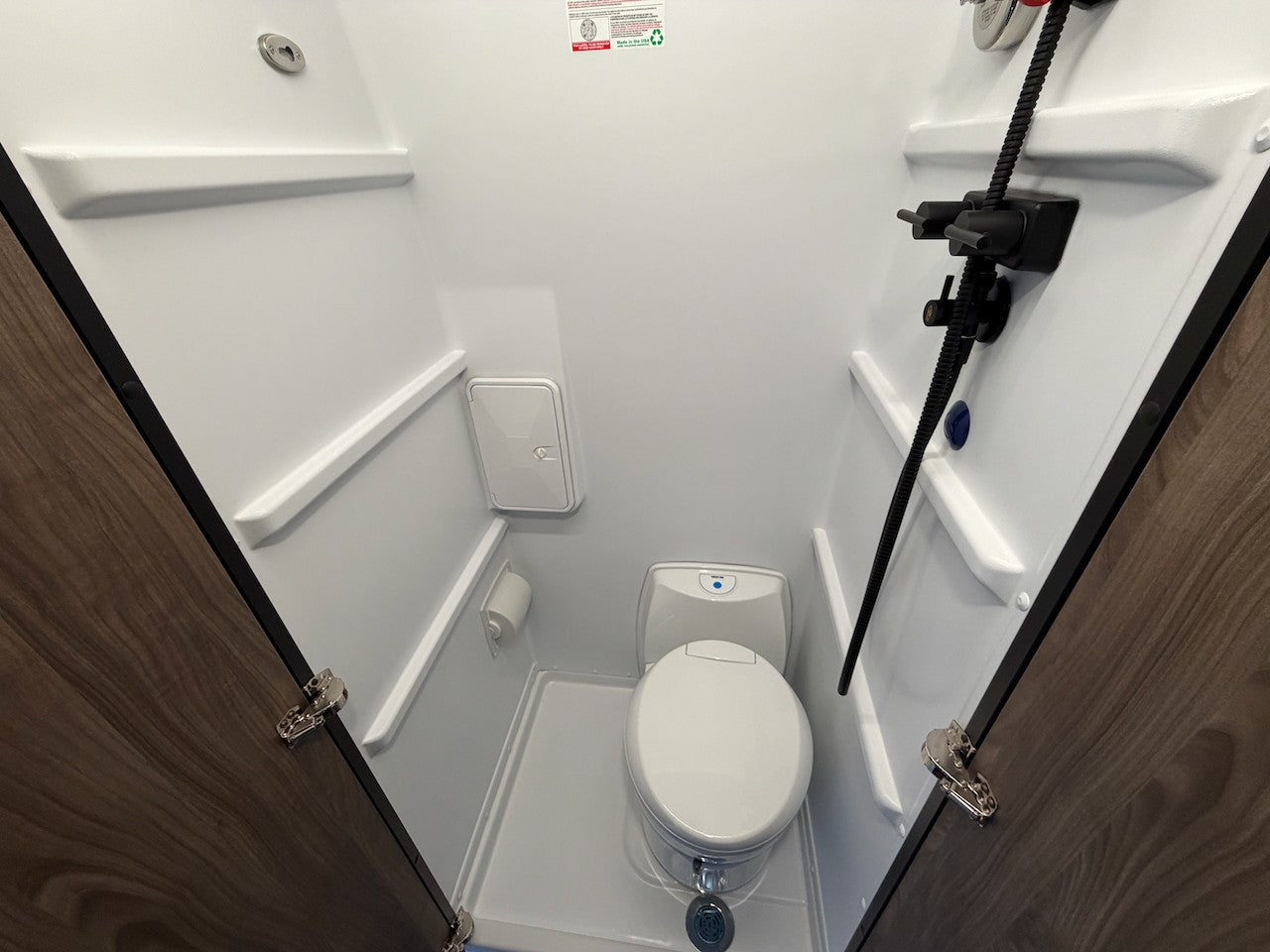 Inside an rv rental: a compact bathroom with white toilet, shower, & molded shelves, designed for space-saving. — photo 7