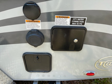 Crucial RV rental hookups: 30A power and city water (max 50 PSI) connections, plus lower service access points.