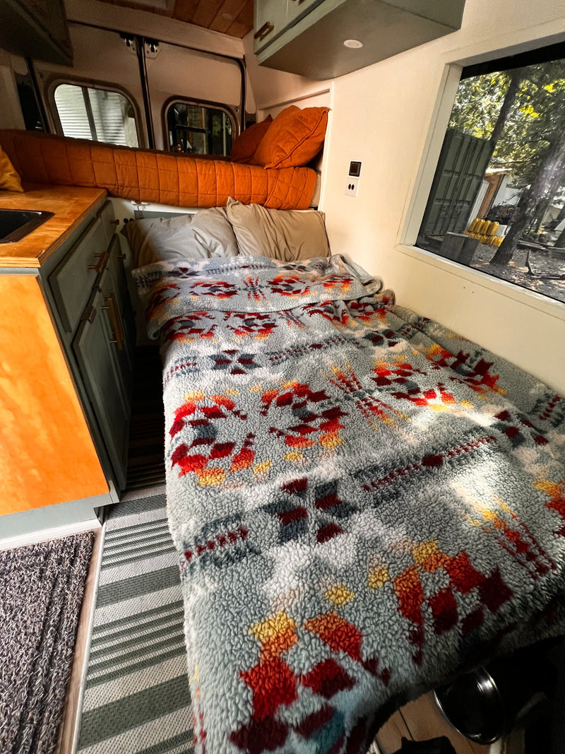  and spacious living area.|This compact RV rental interior features a cozy bed — photo 4