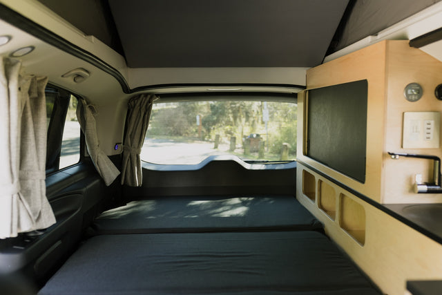 and waterfront city skyline make for great van life.|An RV rental's cozy interior features: a Victron battery monitor (13.2V)