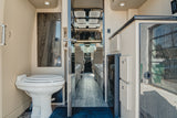 Step inside this RV rental: a modern interior with a compact toilet, an open aisle, and the driver's cabin visible upfront.