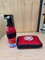 Essential RV rental safety gear: a fire extinguisher and a red first aid kit ready for emergencies on a wood surface.