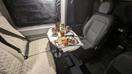 Cozy RV rental interior: A charcuterie board, wine, and comfortable seating arranged for an intimate meal.