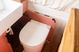 A compact Separett composting toilet next to a sink in a coral vanity, showcasing the efficient bathroom in this RV rental.